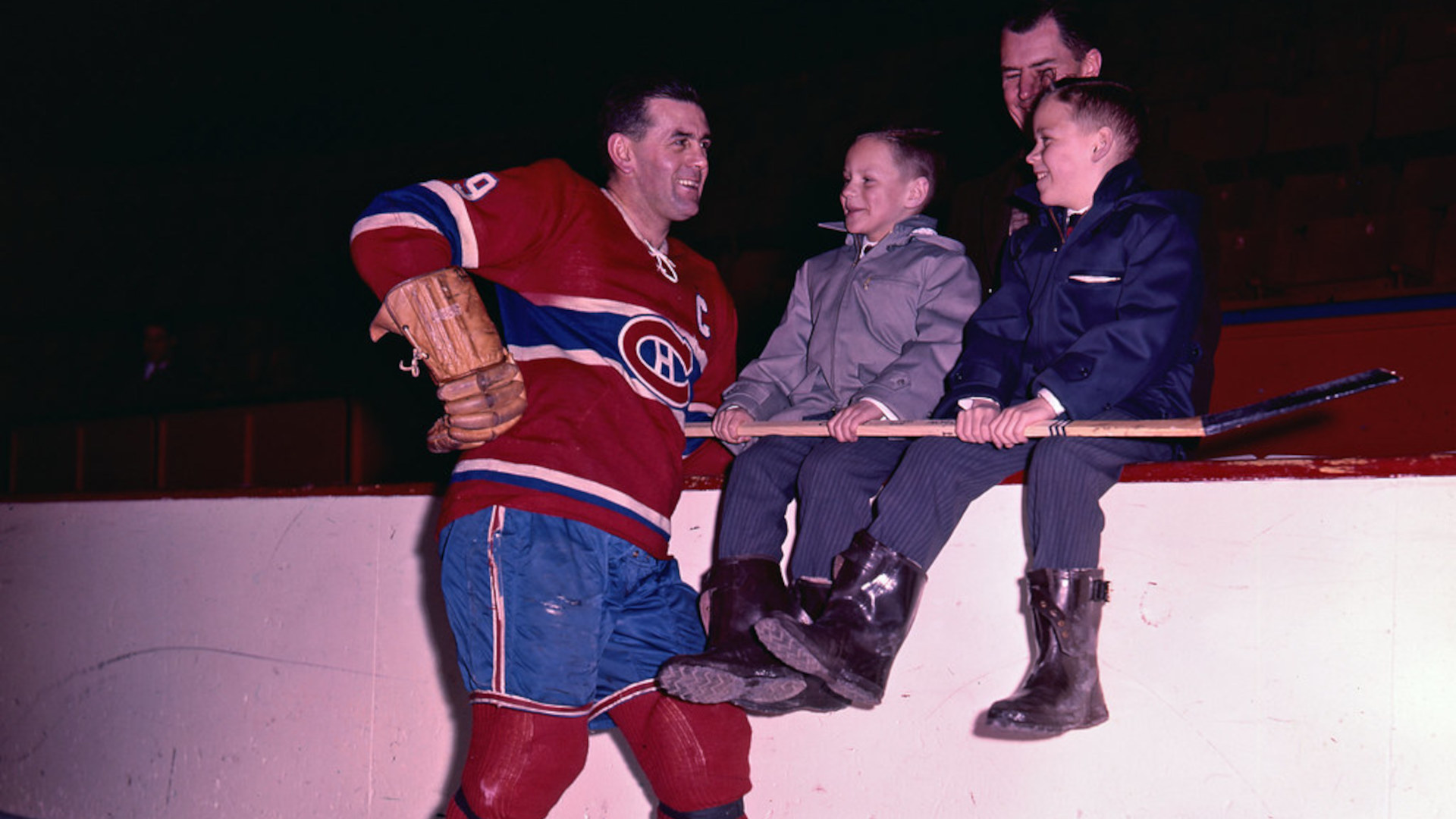 Maurice Richard posant pour une photo avec deux enfants.