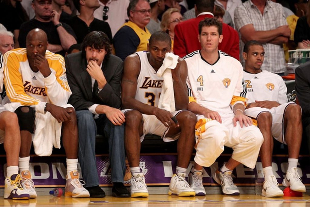 Photo du banc de touche des Lakers de Los Angeles avec Adam Morrison en veste de costume et en jeans.