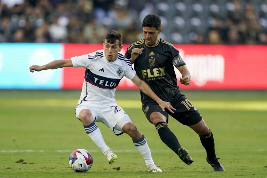 Un joueur du Los Angeles FC tente de tacler un attaquant des Vancouver Whitecaps.