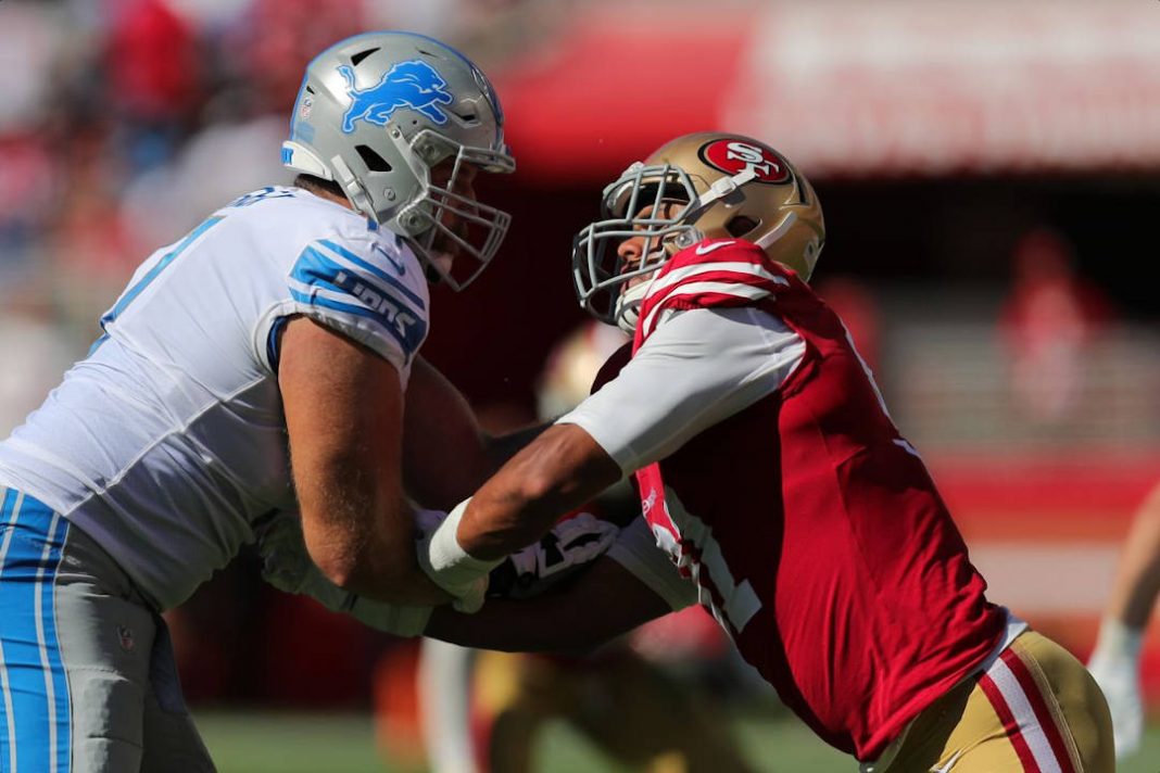 Detroit Lions player trying to get the ball from the 49ers
