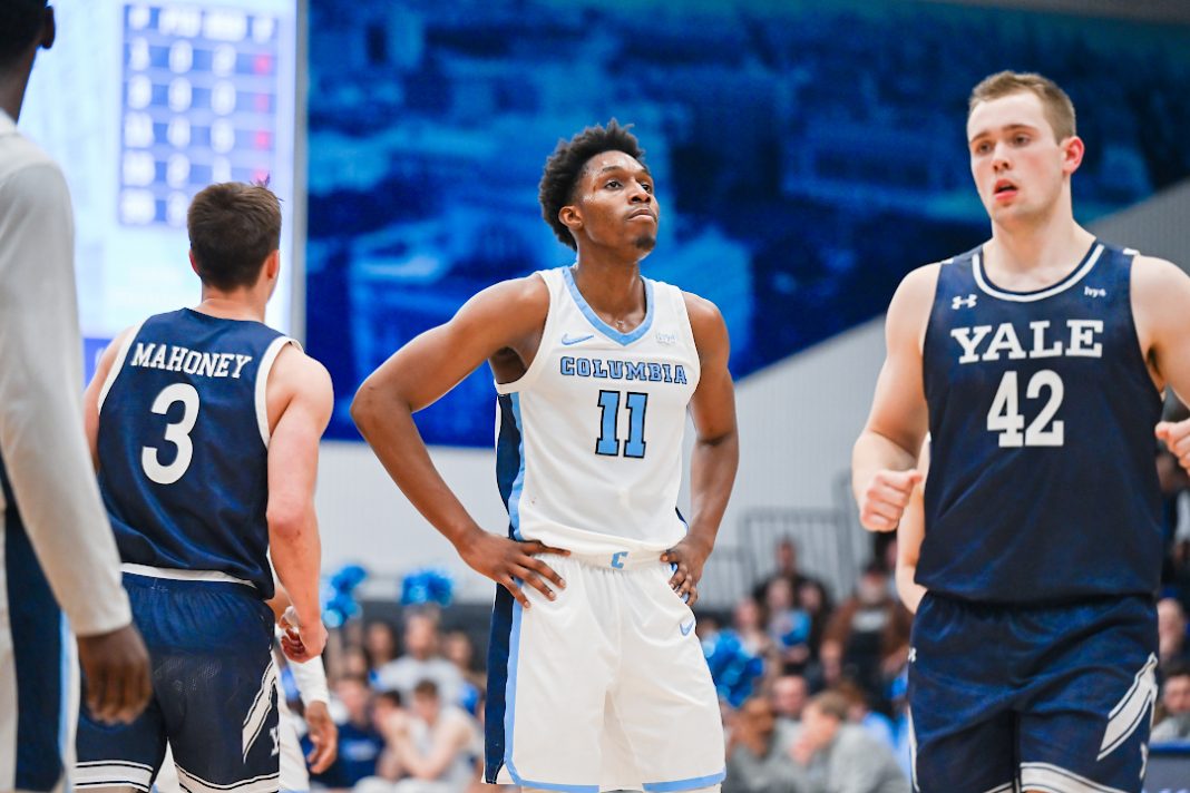 A Columbia Lions basketball player stands with his hands on his hips.