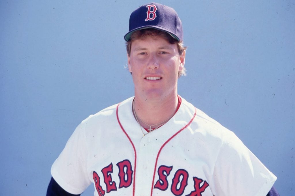 Roger Clemens poses in a Boston Red Sox hat and jersey
