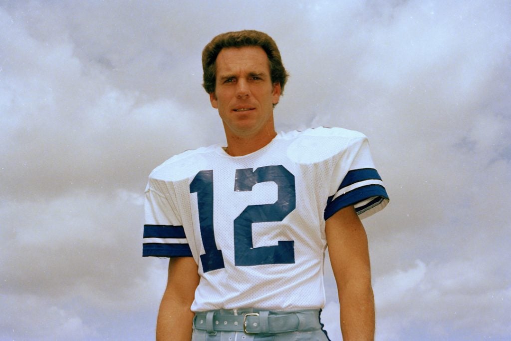 Roger Staubach posing in a Dallas Cowboys jersey