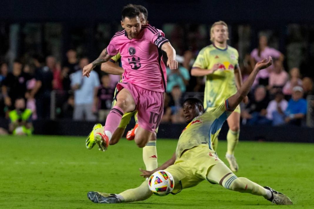 Lionel Messi jumps over a tackle