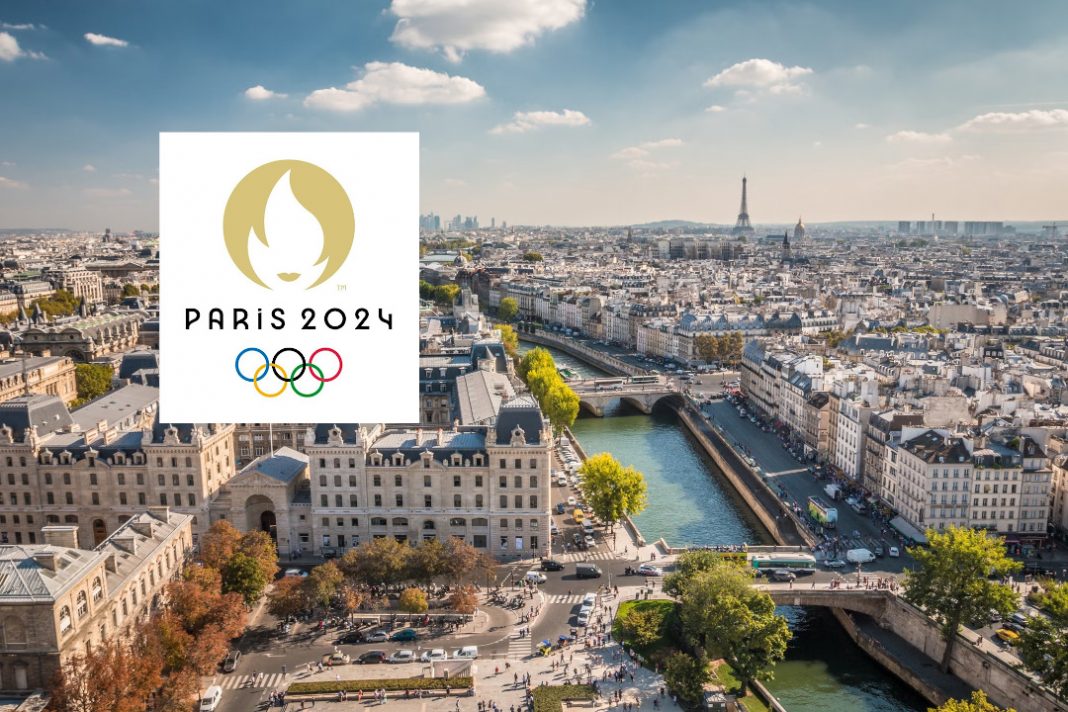 A photo of the Paris skyline with a Paris 2024 Olympics Logo over the top